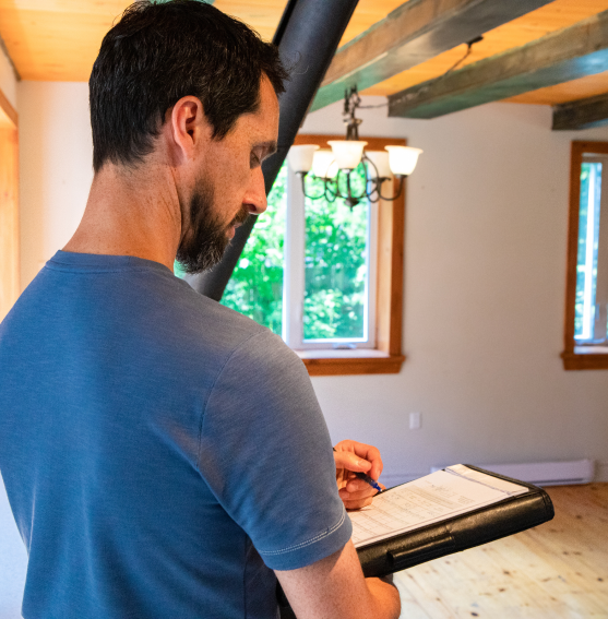 A man holding a clipboard while standing in a room.