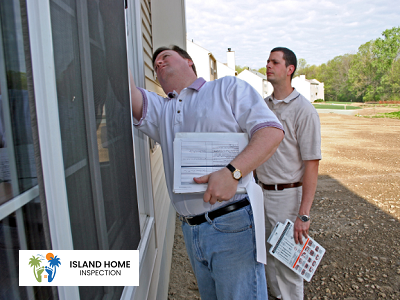 Two home inspectors examining the exterior of a building.